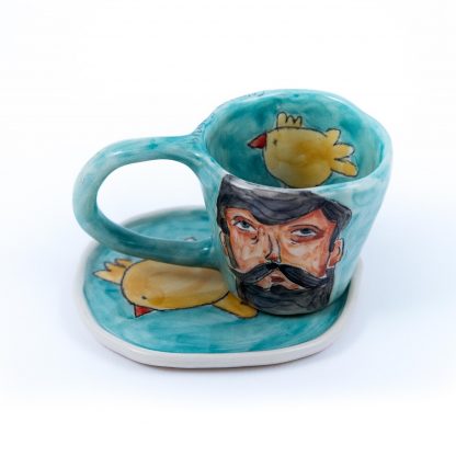 man portrait on blue handmade pottery cup